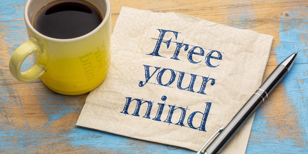 free your mind reminder note - handwriting on a napkin with a cup of coffee